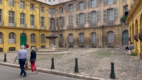 Old-historical-architecture-of-Aix-en-Provence-with-stone-fountain-in-France,-handheld-view