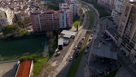 Tram-passing-on-the-green-tramway-surrounded-by-high-buildings-and-traffic