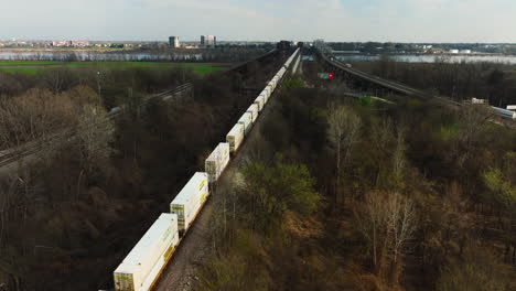 Long-Freight-Train-With-Intermodal-Running-Through-the-Railway-Along-The-Highway-At-West-Memphis-In-Arkansas,-USA