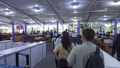 Foreigner-oversea-buyers-queue-at-registration-desk-at-canton-fair-2024-in-Guangzhou,-China