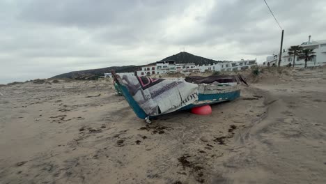 On-the-sandy-shore,-weathered-fishing-boats-rest,-reflecting-the-rustic-charm-and-gradual-aging-of-fishing-gear-in-coastal-villages