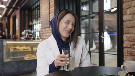 Silly-woman-drink-beverage-with-straw-while-make-flirting-facial-expressions