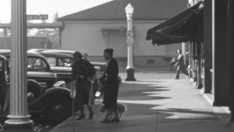 Zwei-Frauen-Und-Ihr-Hund-Gehen-In-Den-1930er-Jahren-In-Einer-US-amerikanischen-Stadt-Zu-Einem-Oldtimer