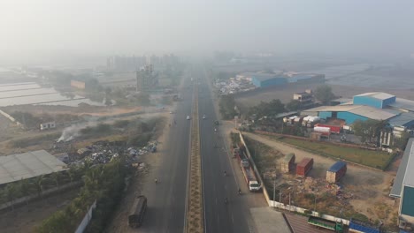 aerial-drone-view-Drone-camera-is-moving-towards-the-highway,-there-is-a-bottom-on-both-sides-of-the-highway-and-a-huge-pile-of-garbage-is-visible-on-one-side-of-the-highway-which-is-polluting