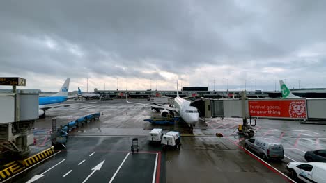 Vehículos-Terrestres-Y-Aviones-En-Tiempo-Nublado-En-El-Aeropuerto-De-Schiphol-En-Amsterdam,-Países-Bajos