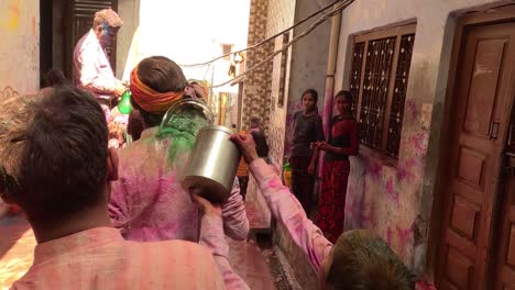 pov-shot-Men-are-walking-through-a-small-alley-and-a-small-boy-is-throwing-a-bucket-full-of-water