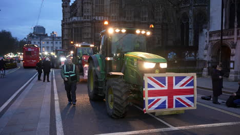 A-convoy-of-tractors-with-placards-on-the-front-arrive-in-Westminster-at-dusk-on-a-protest-defending-British-farmers