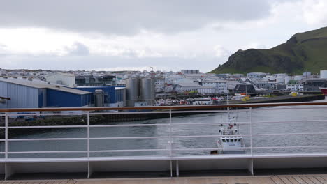 Vestmannaeyjar,-Islandia,-La-Parte-Trasera-Del-Crucero-Que-Sale-Del-Puerto,-Los-Edificios-Frente-Al-Mar-Y-La-Terminal