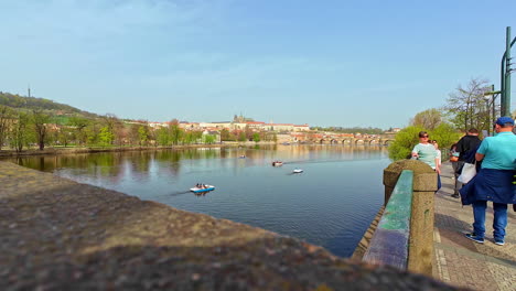 Shot-of-Old-Town-from-over-Charles-Bridge-with-river-Vltava-flowing-through-Prague,-Czech-Republic-on-a-sunny-day