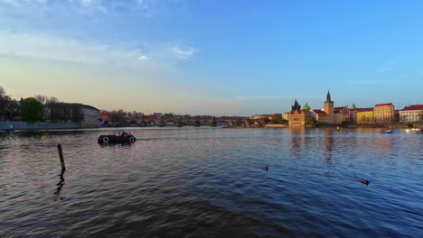Static-shot-of-the-view-of-the-Vltava-River-in-downtown-Prague-at-sunset,-the-sky-is-blue