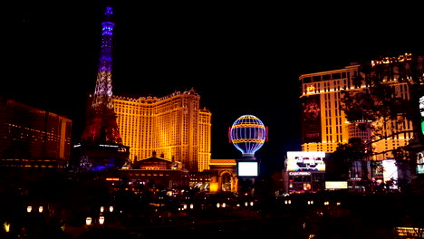 Las-Vegas,-EE.UU.-Por-La-Noche,-Iluminación-Colorida-En-Los-Edificios-Del-Strip,-El-Casino-Del-Hotel-París,-La-Réplica-De-La-Torre-Eiffel-Y-El-Globo