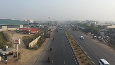 aerial-drone-view-The-drone-camera-is-moving-to-the-right-side-showing-large-factories-and-vehicles-moving-on-the-highway