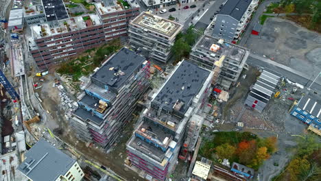 Descending-aerial-footage-of-work-on-two-buildings-encased-in-metal-scaffolding