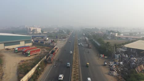 aerial-drone-view-The-drone-camera-is-moving-upwards-and-vehicles-are-seen-moving-on-the-highway-and-large-factories-are-also-visible