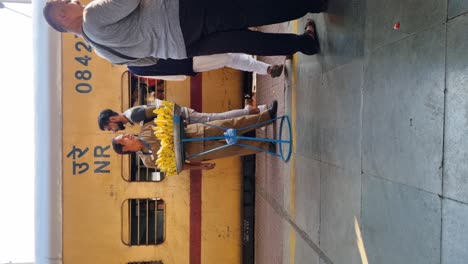 Toma-De-Vídeo-Vertical-De-Un-Vendedor-Vendiendo-Plátanos-En-La-Plataforma-De-Una-Estación-De-Tren-En-La-India.