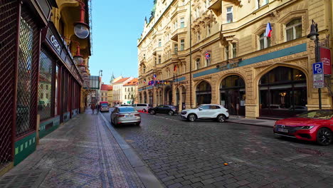 POV-Aufnahme-Bei-Einem-Spaziergang-Durch-Die-Straßen-Von-Prag-An-Einem-Frühen-Morgen-Mit-Autos,-Die-Auf-Beiden-Seiten-Der-Straße-Geparkt-Sind