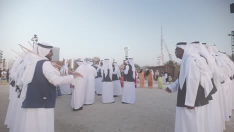 Danza-Tradicional-De-Los-Emiratos-Árabes-Unidos-En-Heritage-Village-Mientras-Canta-Durante-Una-Puesta-De-Sol-épica