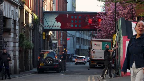 People-Walk-On-Tib-Street-With-Colorful-Art-In-Northern-Quarter,-Manchester,-United-Kingdom,-wide-shot