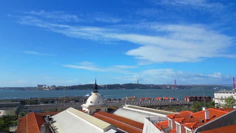 Going-up-between-buildings-towards-the-Cais-do-Sodre-train-station-with-the-Tagus-River-in-the-background,Lisbon,Portugal