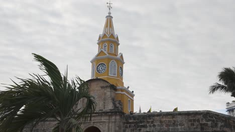 Establishing-pan-of-yellow-building-with-white-trim-of-Torre-del-Reloj-in-Cartagena-Colombia