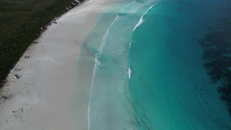 Toma-Aérea-De-Arriba-Hacia-Abajo-De-Una-Playa-De-Arena-Con-Aguas-Cristalinas-Del-Océano-En-Australia