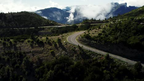 Drone-of-White-Clouds-and-Scenic-Mountain-Road,-Aerial-of-Madeira