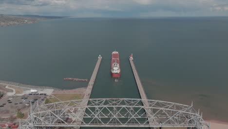Aerial,-Cargo-Ship-Sailing-from-Duluth-Harbor-into-Lake-Superior