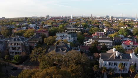 Aerial-rising-and-panning-shot-of-antebellum-mansions-along-the-South-Battery-waterfront-during-sunset-in-Charleston,-South-Carolina