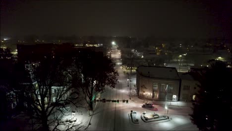 Toma-Aérea-Sobre-Una-Carretera-Nevada-En-El-Centro-De-Lititz-Por-La-Noche,-En-Dirección-Norte.