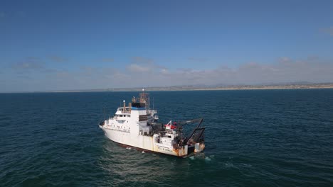 Vista-Aérea-Del-Barco-De-Investigación-Pesquera-Estadounidense-En-La-Costa-Del-Océano-Pacífico-En-Del-Mar,-San-Diego,-California.