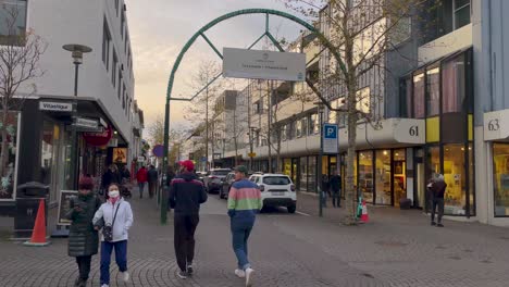 Daily-life-in-downtown-Reykjavik-with-walking-people-and-vehicles,-handheld-view