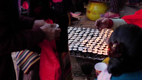 Exchanging-of-money-for-butter-lamps-at-Boudhanath-Temple,-Kathmandu,-Nepal