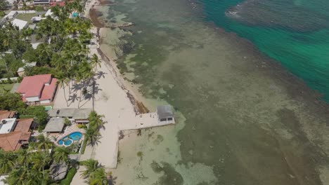 Drone-flying-over-Playa-Guayacanes-beach,-San-Pedro-de-Macoris-in-Dominican-Republic