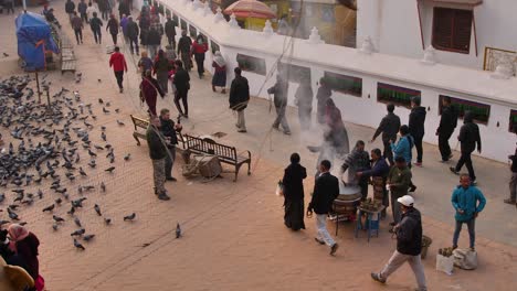 Mittlere-Aufnahme-Von-Menschen,-Die-Im-äußeren-Teil-Des-Bodnath-Tempels-In-Kathmandu,-Nepal-Herumlaufen