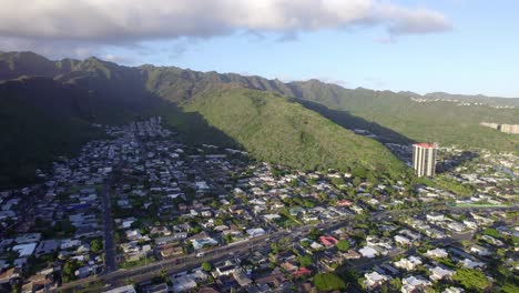 drone-footage-backing-away-from-the-city-of-Honolulu-Hawaii-on-the-island-of-Oahu-to-show-the-city-as-it-is-nestled-within-the-mountains-and-edged-by-beaches-and-Mamala-Bay