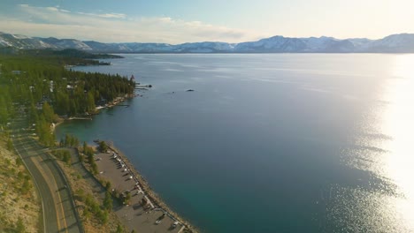 Aerial-view-of-Lake-Tahoe-coastline-looking-at-mountains-and-sunset