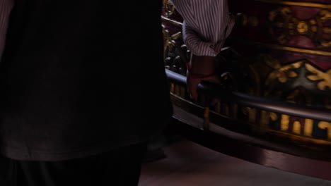 Close-shot-of-people-spinning-a-large-prayer-wheel-in-Boudhanath-Temple,-Kathmandu,-Nepal