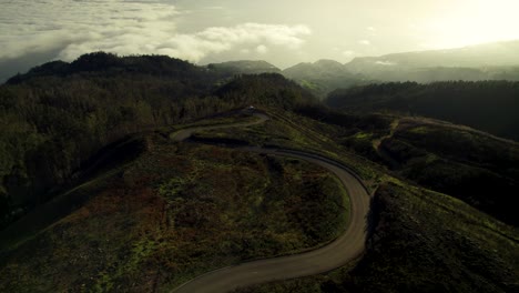 Drohnenaufnahmen-Einer-Malerischen-Kurvenreichen-Straße-über-Den-Wolken-In-Den-Bergen