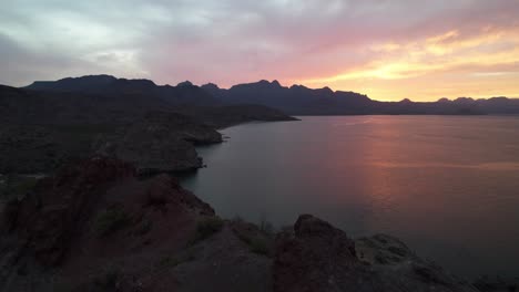 Rocky-Mountains-Overlooking-The-Calm-Sea-At-Sunset-In-Baja-California,-Mexico