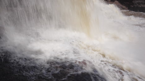 Nahaufnahme-Eines-Mächtigen-Wasserfalls-Auf-Zerklüftetem,-Felsigem-Gelände