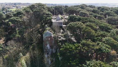 Flight-over-old-German-fortifications-surrounded-by-woodland-and-taken-over-by-nature-in-Guernsey-Channel-Islands-on-bright-day