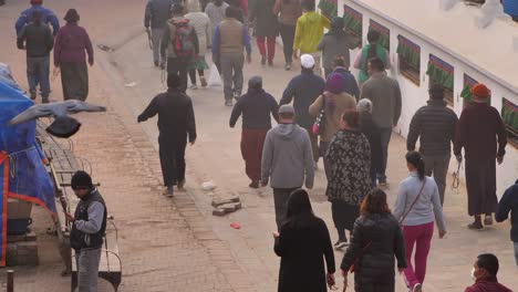 Elevated-view-of-people-walking-around-the-outer-section-of-Boudhanath-Temple,-Kathmandu,-Nepal