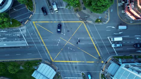 Vista-Aérea-De-Drones-De-Los-Vehículos-De-Tráfico-En-La-Autopista-Calle-Muy-Transitada-Con-Luces-De-Intersección-Rotonda-Parque-Farrer-Singapur-Asia-Transporte