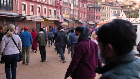 Ground-level-view-of-people-walking-around-Boudhanath-Temple,-Kathmandu,-Nepal