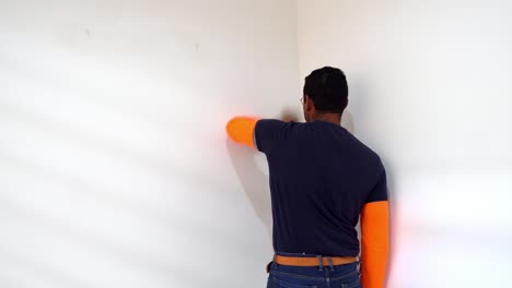 Male-Painter-Cleaning-Wall-Before-Painting---Close-Up