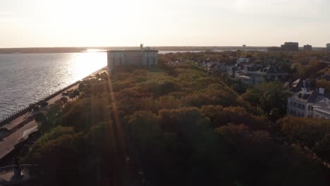 Toma-Aérea-Baja-Volando-Sobre-El-Jardín-White-Point-En-Oyster-Point-En-Charleston,-Carolina-Del-Sur-Durante-La-Puesta-De-Sol