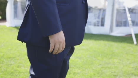 Groom-puts-hands-in-pockets