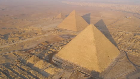 Aerial-perspective-unveils-the-awe-inspiring-Great-Pyramids-of-Giza-and-the-surrounding-Pyramids-Plateau-in-Egypt,-symbolizing-the-enduring-legacy-of-ancient-civilization-and-the-human-ingenuity