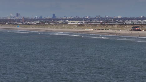 Hoek-van-Holland-Beach,-The-Netherlands---White-Waves-Crash-Onto-the-Pristine-Beach-Shoreline---Wide-Shot