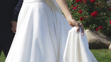 Bride-swishes-gown-as-she-walks-with-groom